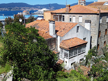 Foto de una casa antigua con su jardin y la Ría de Vigo de fondo.